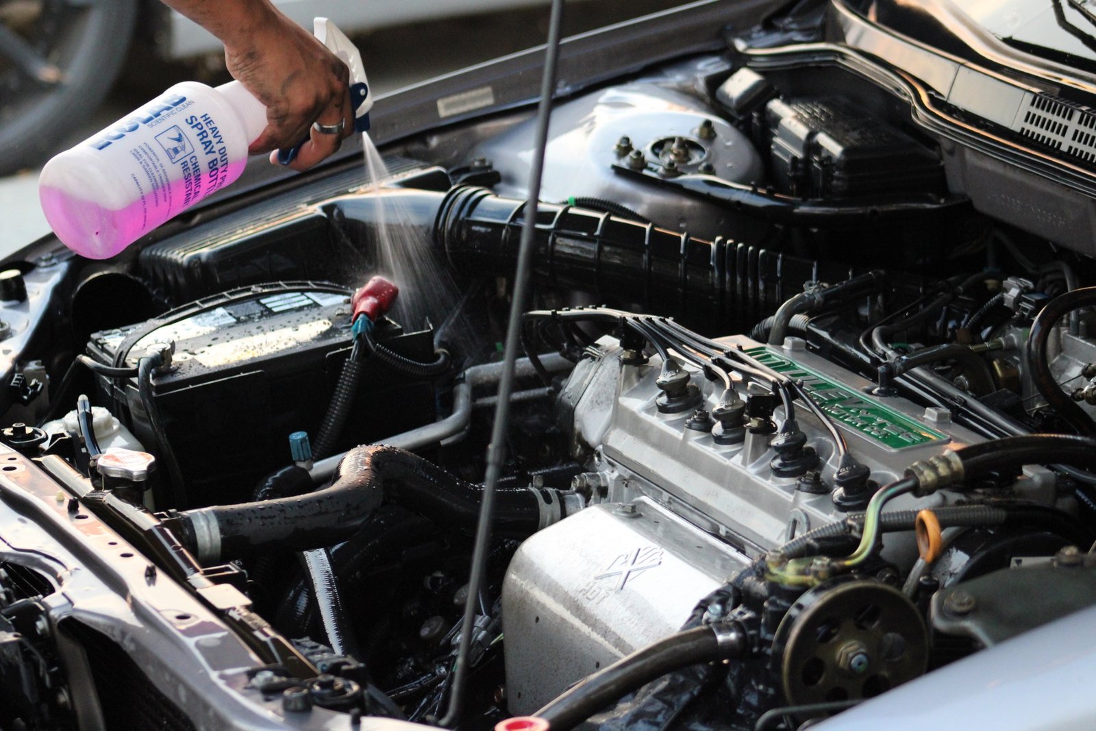 Engine bay being degreased and detailed by hand